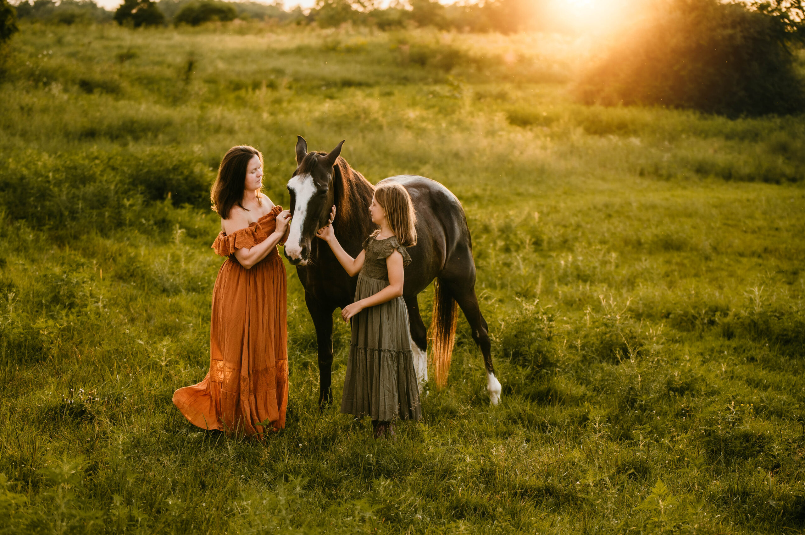 mom and daughter petting horse